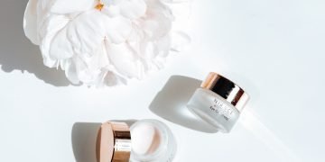 white flower beside pink nail polish