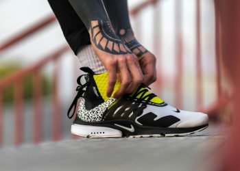 unpaired white, black, and yellow Nike shoe