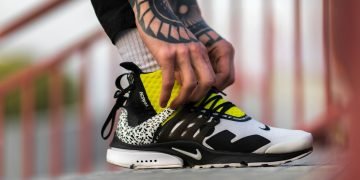 unpaired white, black, and yellow Nike shoe