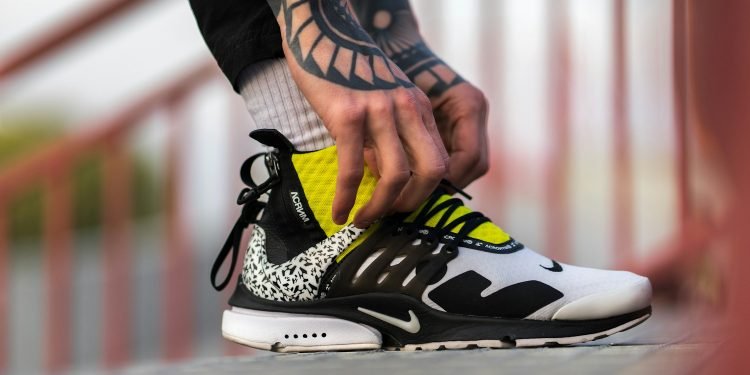 unpaired white, black, and yellow Nike shoe