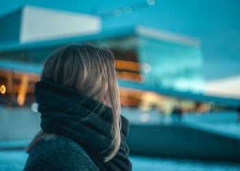 woman standing near building under dark cloudy sky