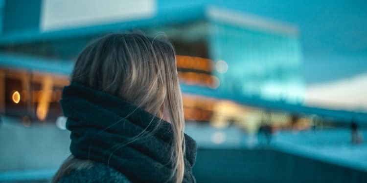 woman standing near building under dark cloudy sky