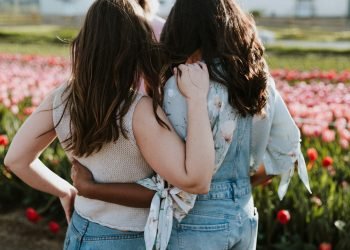 two women in front of flowers