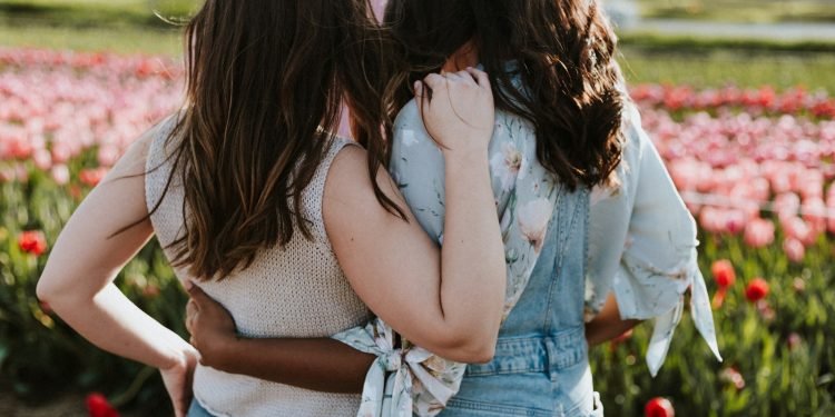 two women in front of flowers