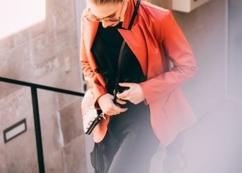 woman wearing orange jacket and black pants with black inner shirts