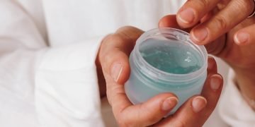 person holding blue plastic container