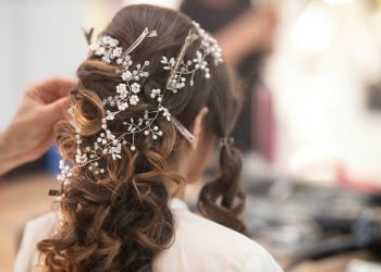 woman in white shirt with brown and white floral hair tie