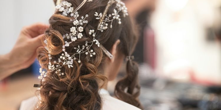 woman in white shirt with brown and white floral hair tie