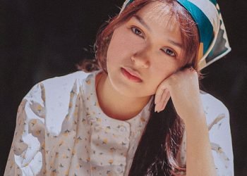 a woman sitting at a table with her hand on her head