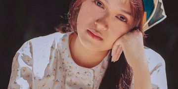 a woman sitting at a table with her hand on her head
