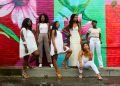 six women wearing white pants posing