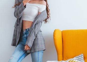 woman in blue denim jeans sitting on yellow couch