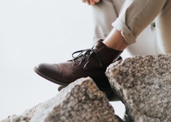 man sitting on gray rock formation