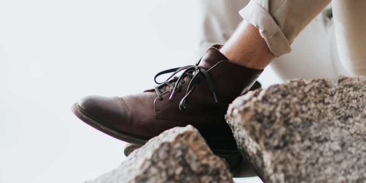 man sitting on gray rock formation