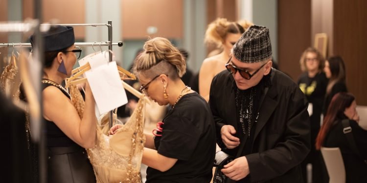 Fashion designers prepare backstage for a show.