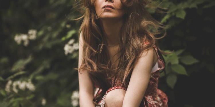 woman doing pose surrounded by flowers