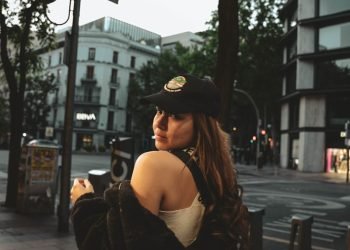 a woman standing on a sidewalk looking at her cell phone