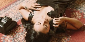 A woman laying on the floor with a purse