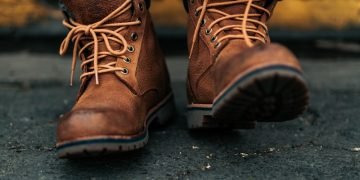 photography of person lacing his/her boots