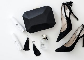 a pair of black high heels, a black purse, and a pair of white
